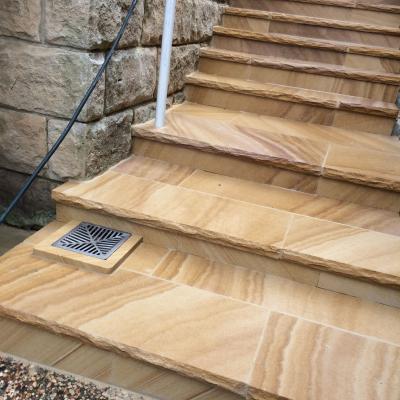 Medium brown sawn finish rock faced sandstone paving stairs 