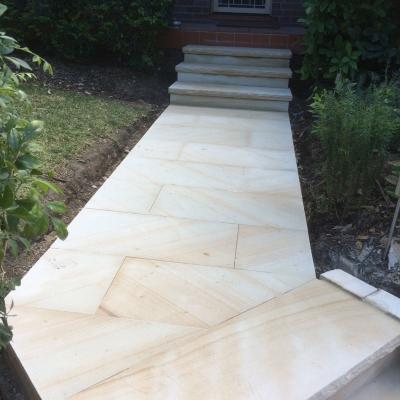 Light brown sawn finish sandstone paving  path and stairs with rock faced edge